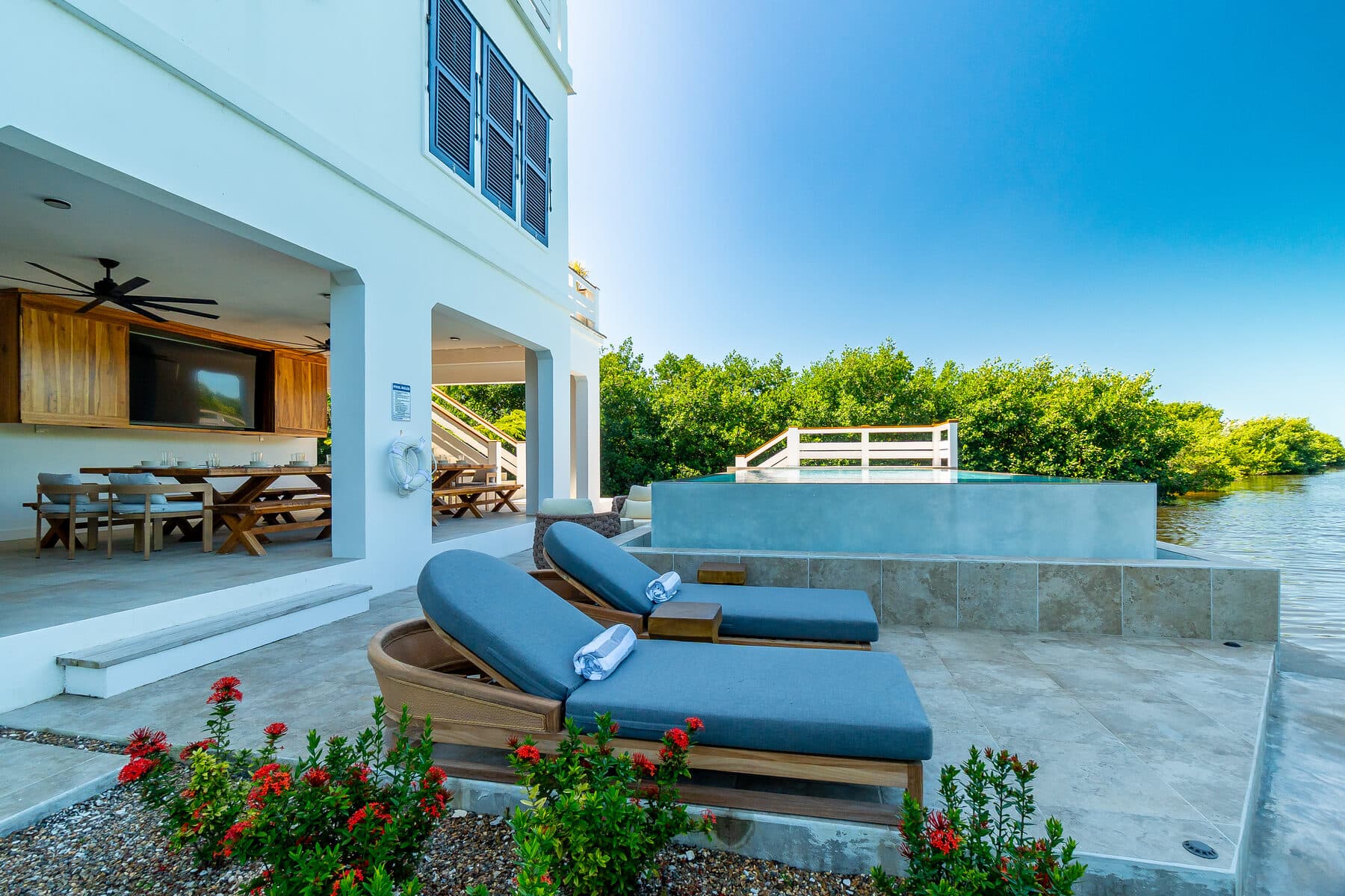 Teak sun loungers beside the BelaDia canal-side infinity pool at golden hour